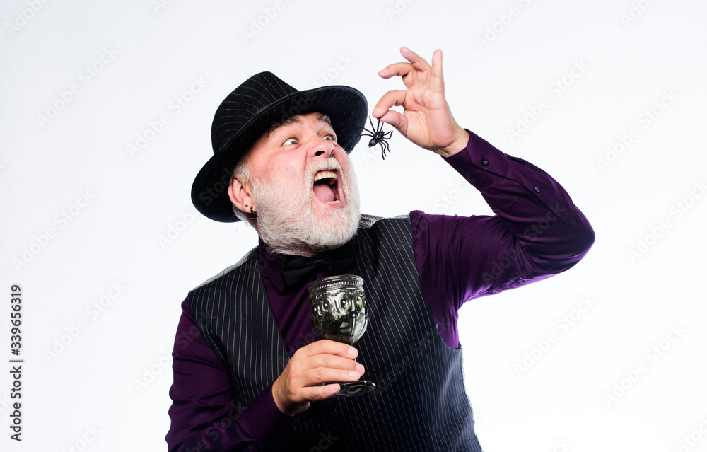 Happy Haunting. halloween holiday costume. mature man magician in witch hat. evil wizard cooking magic potion with spider. barman make cocktail for halloween party. happy halloween Happy Haunting. halloween holiday costume. mature man magician in witch hat. evil wizard cooking magic potion with spider. barman make cocktail for halloween party. happy halloween