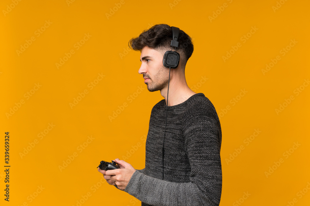 Young man over isolated background playing at videogames Young man over isolated background playing at videogames