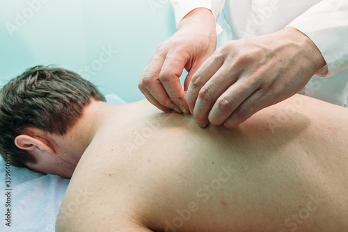 physiotherapist doing back massage to her patient in medical office