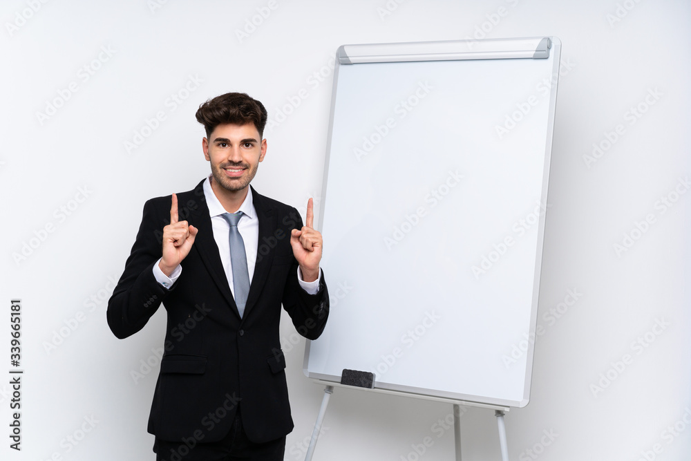 Young businessman giving a presentation on white board pointing up a great idea Young businessman giving a presentation on white board pointing up a great idea