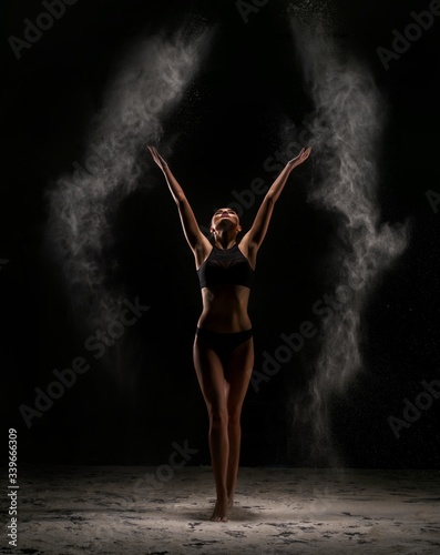 Fototapeta Naklejka Na Ścianę i Meble -  Slim woman in dust cloud shot