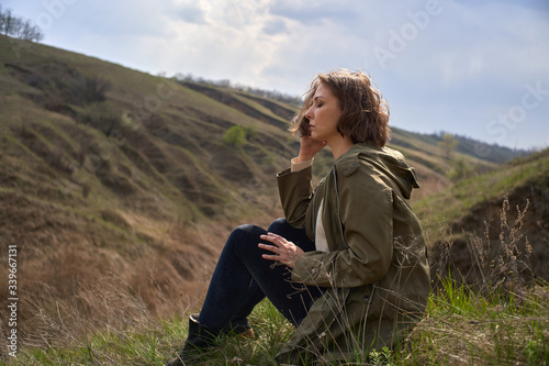 Alone girl on beautiful mountain view feeling free with wind and sky. Isolated woman on nature background, freedom, post apocalypse