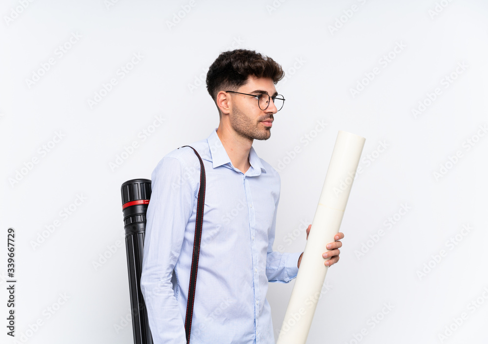 Young architect man over isolated white background looking to the side Young architect man over isolated white background looking to the side