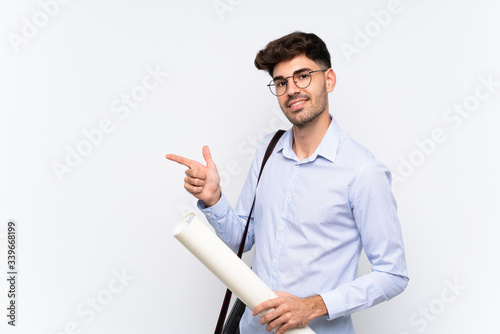 Young architect man over isolated white background pointing finger to the side