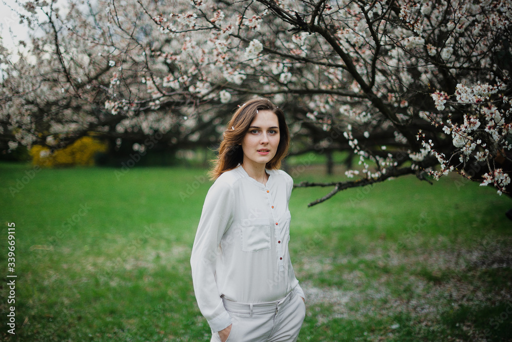 Beautiful young girl is resting and enjoying spring in the spring park Beautiful young girl is resting and enjoying spring in the spring park
