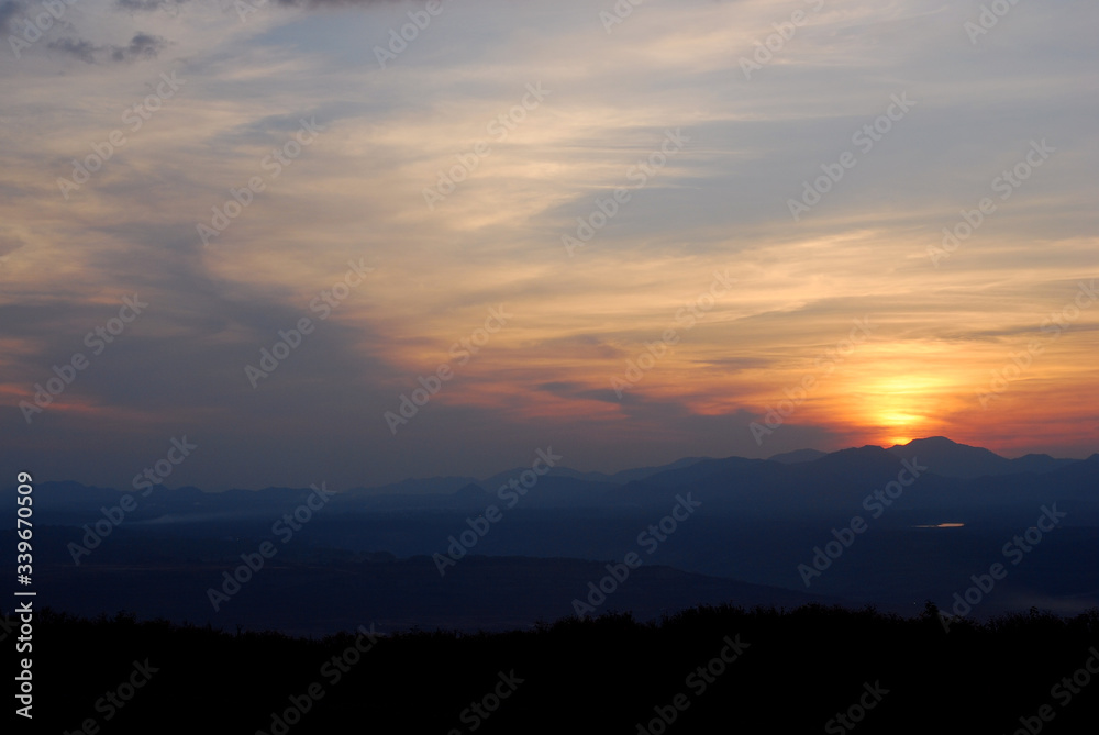 Sunrise among forests and mountains