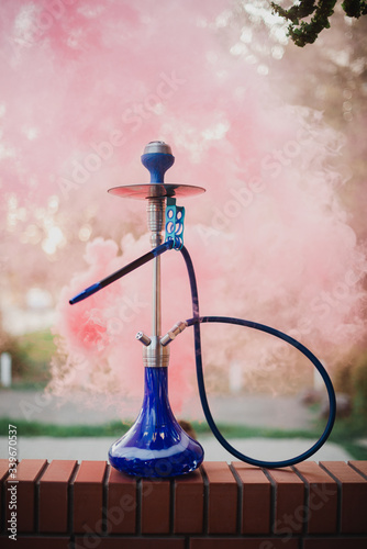 Hookah outdoors on a background of colored smoke