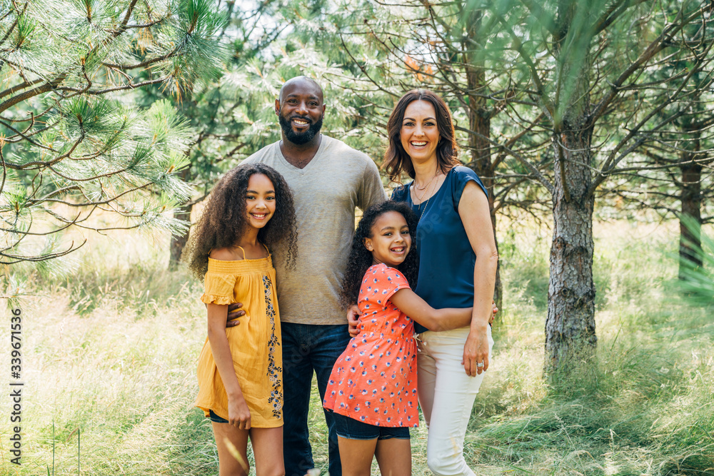 Portrait of smiling mixed race family with two daughters outside Portrait of smiling mixed race family with two daughters outside