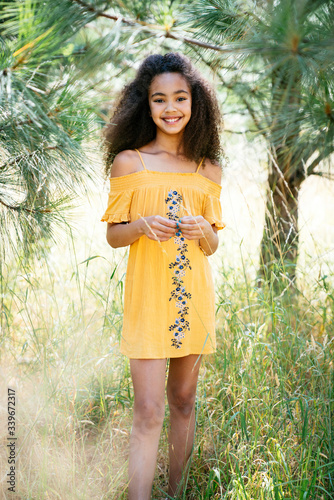 Portrait of smiling curly haired girl outside in nature