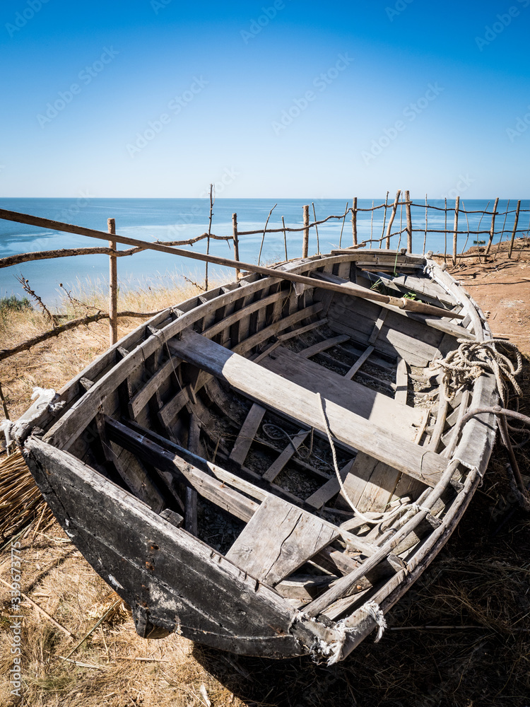 Old empty vintage fishing boat stands on the beach