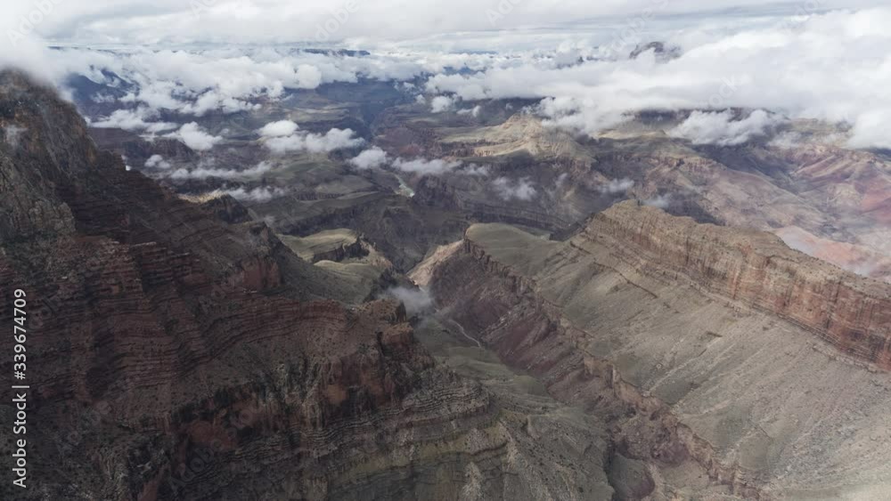 A wide timelapse looking west of clouds flowing inside the Grand Canyon. Clouds pass the camera temporarily obscuring the frame before moving on to reveal the canyon far below. A wide timelapse looking west of clouds flowing inside the Grand Canyon. Clouds pass the camera temporarily obscuring the frame before moving on to reveal the canyon far below.