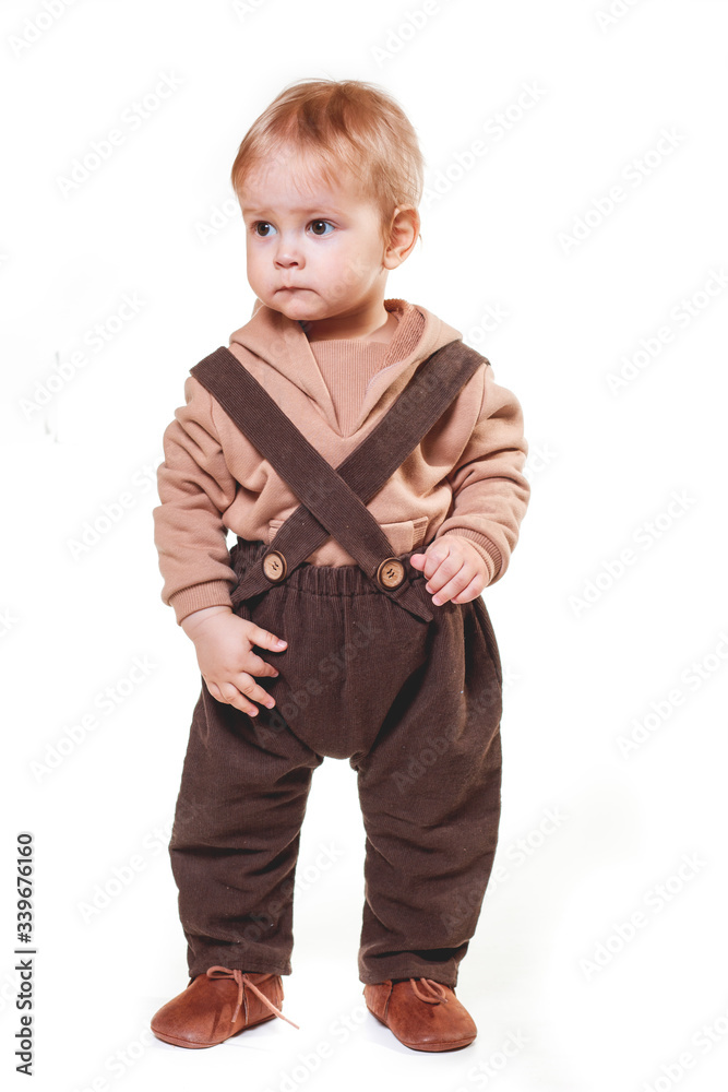 portrait of a charming one-year-old little boy on a white background, dressed in brown trousers, a beige hoodie, portrait of a charming one-year-old little boy on a white background, dressed in brown trousers, a beige hoodie,