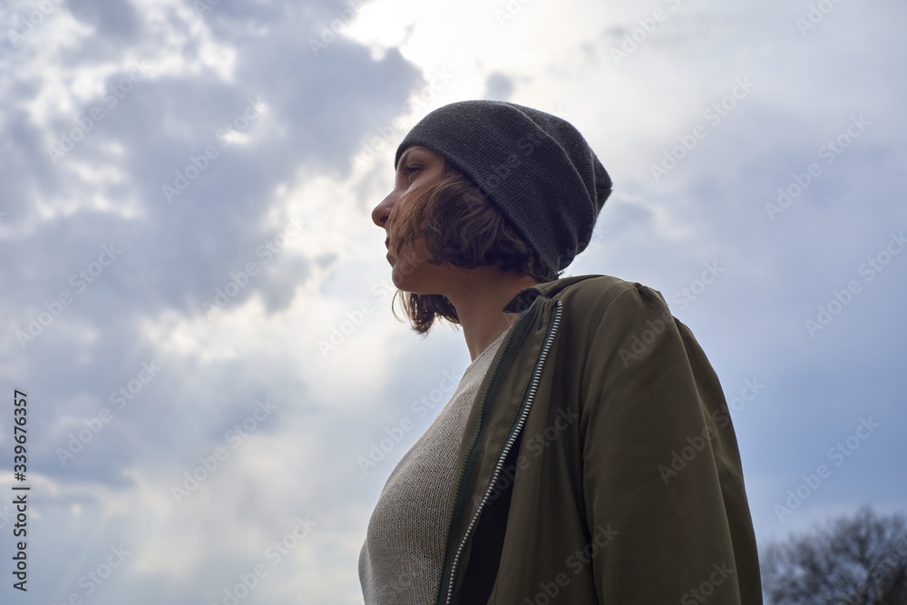 Beautiful girl in gray hat on sky background. Portrait of young woman freedom conception Beautiful girl in gray hat on sky background. Portrait of young woman freedom conception