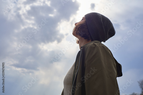Beautiful girl in gray hat on sky background. Portrait of young woman freedom conception