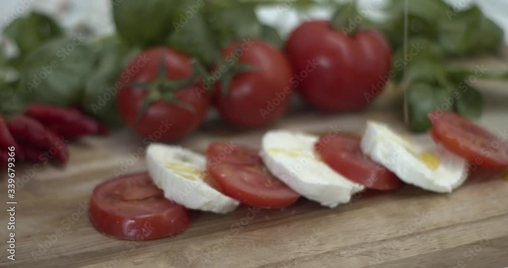 Versare olio extra vergine di oliva su una caprese di pomodoro e mozzarella di bufala italiana Versare olio extra vergine di oliva su una caprese di pomodoro e mozzarella di bufala italiana