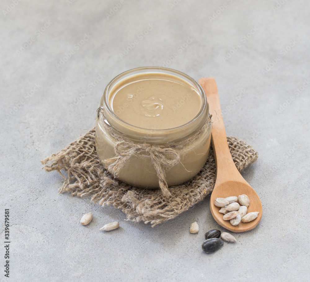 Vegan sunflower paste in a jar in rustic style on a light background Vegan sunflower paste in a jar in rustic style on a light background
