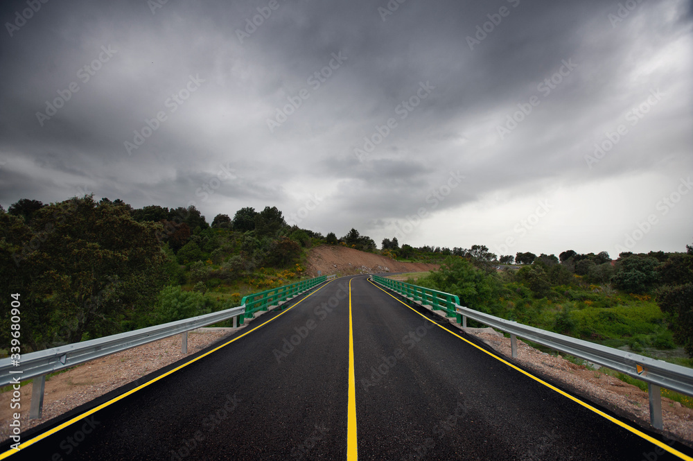 Fototapeta premium Wet asphalt road and rainy clouds in Spain