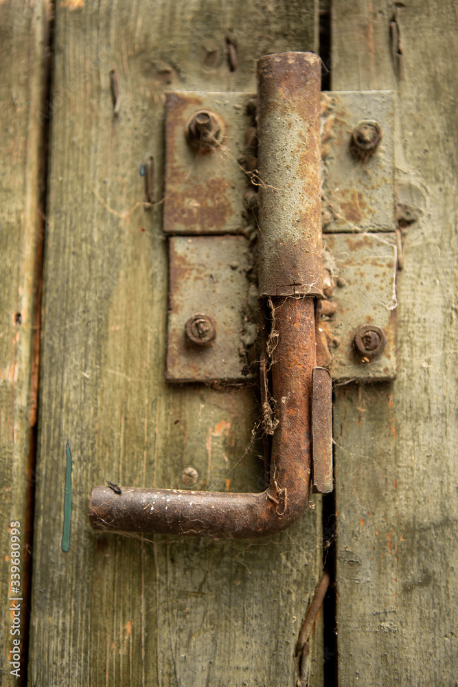 A closeup of a metal old rusty lock on a wooden door A closeup of a metal old rusty lock on a wooden door