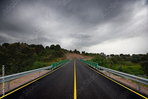 Wet asphalt road and rainy clouds in Spain