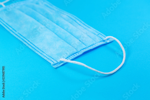 disposable face mask on blue background, respiratory protection
