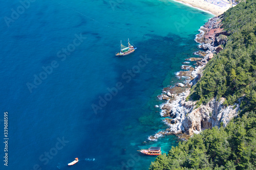 mid-sea, Turkey, Alanya. Paradise tropical lagoon with rocky beach in Alanya, Turkey. Sea and mountains landscape in sunny summer day. Alanya beach panoramic view.