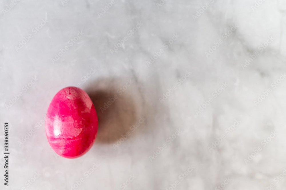 Single easter egg pink color on marble background top view horisontal