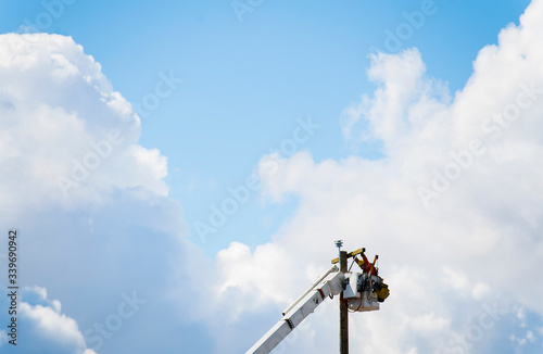 A lineworker is shown working on a utility pole