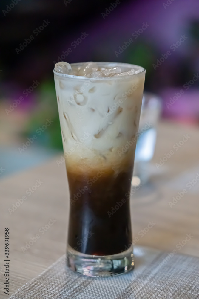 Glass of latte on table with blurred background.
