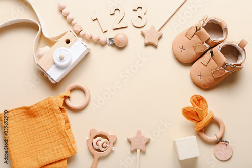 Set of baby shoes, toys and accessories on beige background. Fashion newborn stuff. Flat lay, top view