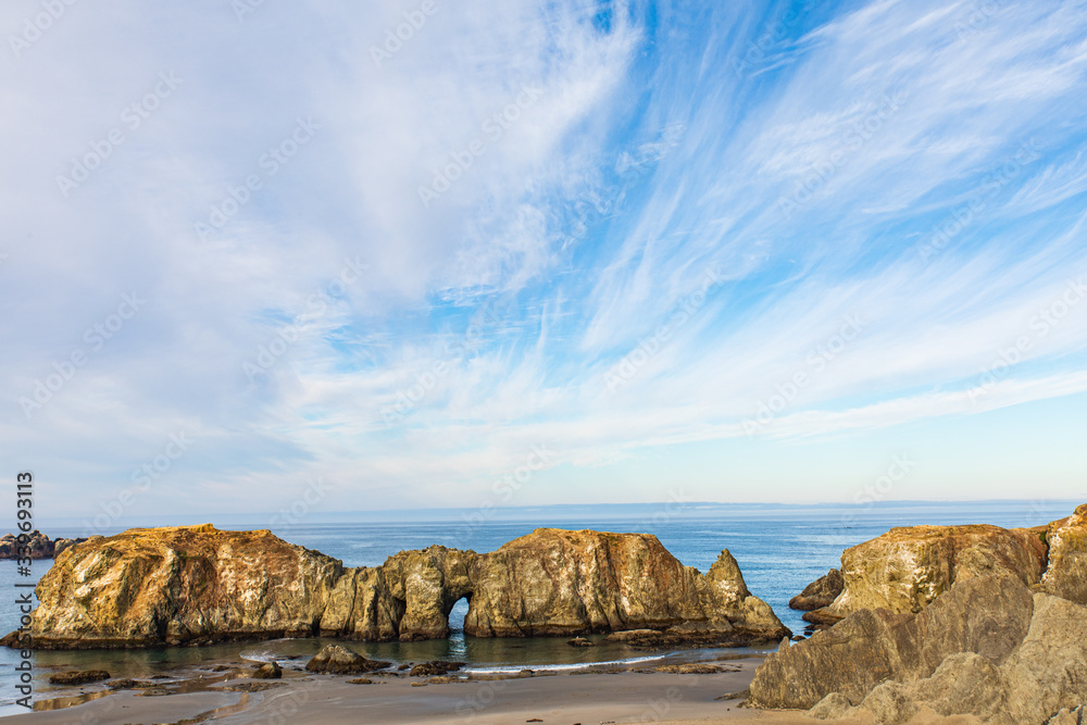 Wide blue skies with high clouds above a large Sea stacks on Bandon beach in Oregon Wide blue skies with high clouds above a large Sea stacks on Bandon beach in Oregon