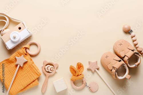 Set of baby shoes, toys and accessories on beige background. Fashion newborn stuff. Flat lay, top view