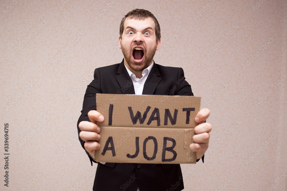 Unemployed in search of work. Man shows the sign I need a job. Concept - human was fired due to the crisis. Adult Male Looking I need a job. Human upset by dismissal. Dismissal. Unemployed in search of work. Man shows the sign I need a job. Concept - human was fired due to the crisis. Adult Male Looking I need a job. Human upset by dismissal. Dismissal.