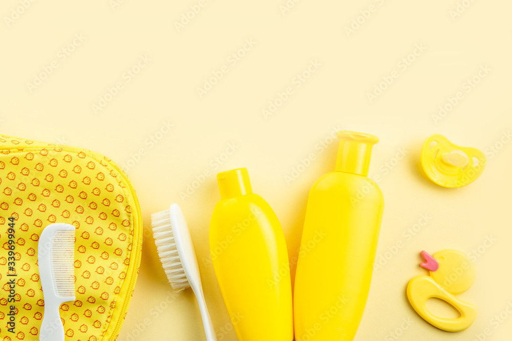 Spa and bath concept. Baby bath set. Rubber duck, washcloth, soap bottle, shampoo, towel and comb on yellow background. Spa and bath concept. Baby bath set. Rubber duck, washcloth, soap bottle, shampoo, towel and comb on yellow background.