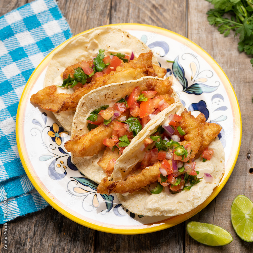 Mexican breaded fish tacos also called ensenada on wooden background