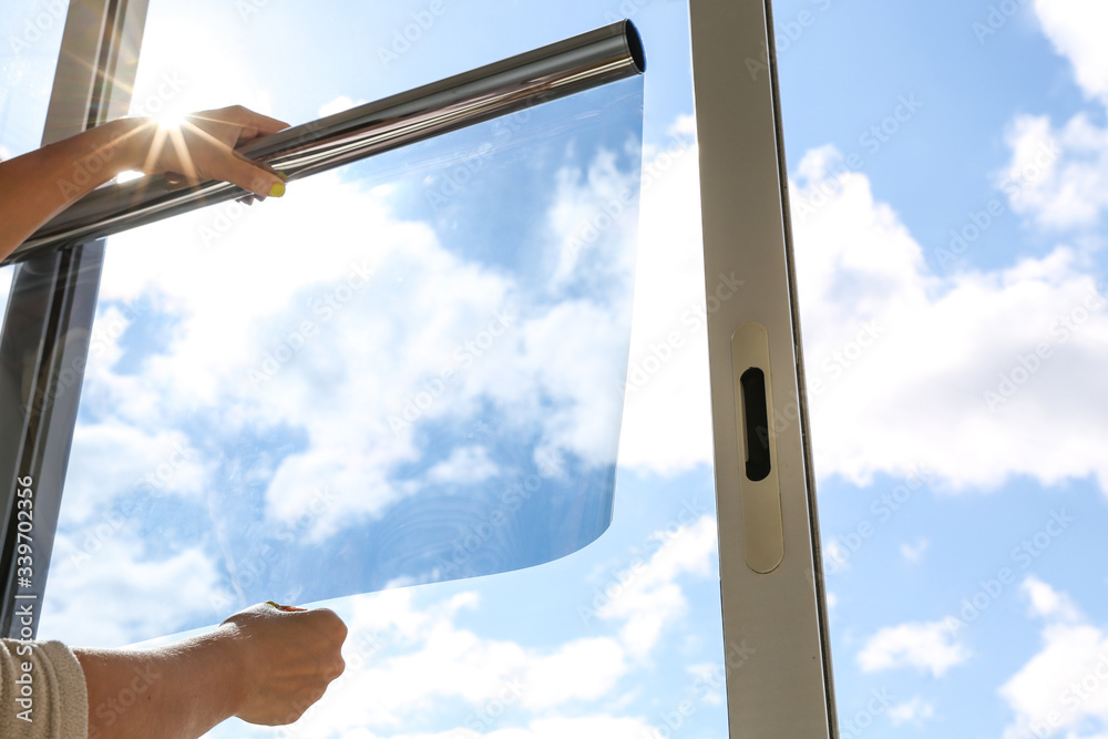 tinted glass in the house. window dimming by dark film. hands apply tint  film to the window. tint film on sky background. window view through tinted  glass Stock Photo | Adobe Stock