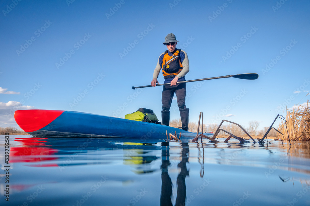 senior male paddling stand up paddleboard
