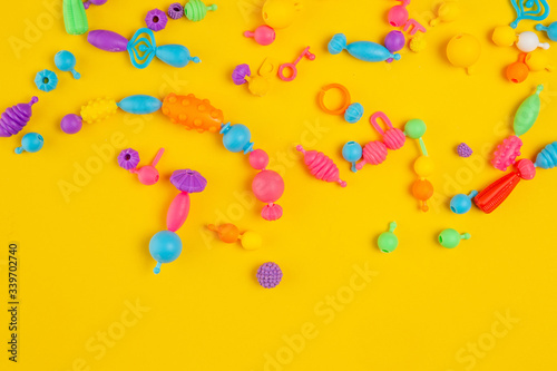 Colored kids toys on yellow background.