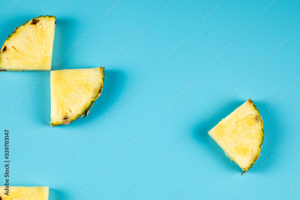 Fresh pineapple cubes shaped and isolated on blue background Fresh pineapple cubes shaped and isolated on blue background