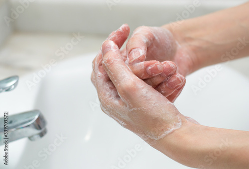 Hand washing with soap and water to prevent the spread of bacteria and viruses like coronavirus or covid-19 photo