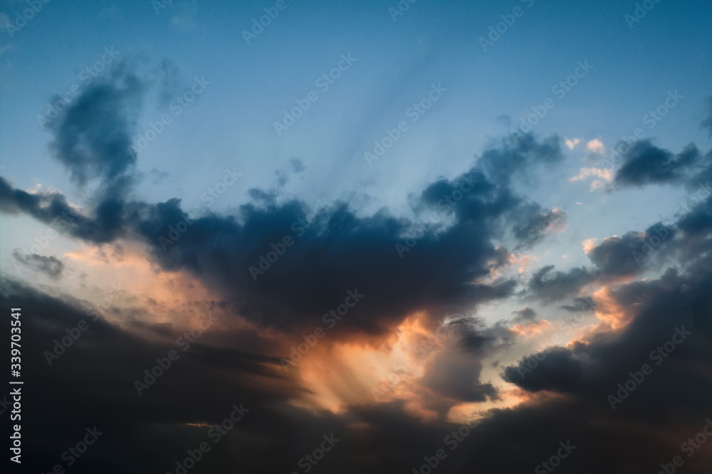 The sky at sunset. Cumulus clouds lit by the rays of the setting sun.