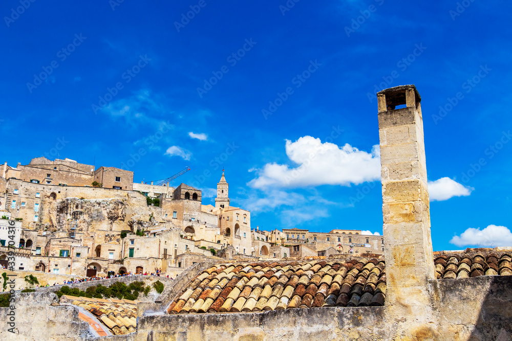 Traditional high chimney in front of beautiful Matera old town view in Matera, Province of Matera, Basilicata Region, Italy