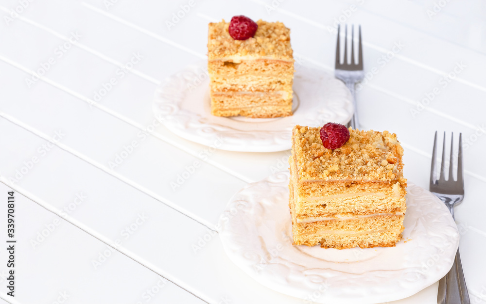 Two pieces of homemade honey cake on white wooden table. Selective focus. Two pieces of homemade honey cake on white wooden table. Selective focus.