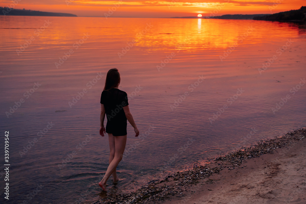 girl doing pilates, yoga on the beach, at sunset
