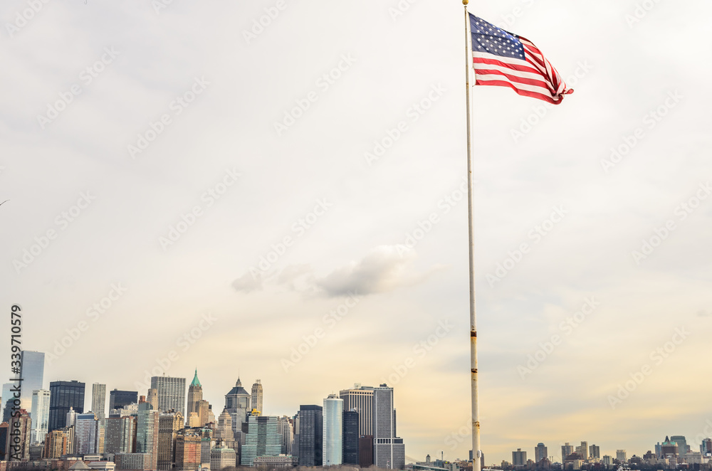 The American Flag Waves Proudly. Manhattan, New York City, Cityscape in Background. USA
