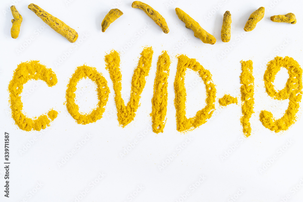 turmeric on a white background is scattered with the word cavid-19 as a natural yellow antiseptic in powder turmeric on a white background is scattered with the word cavid-19 as a natural yellow antiseptic in powder