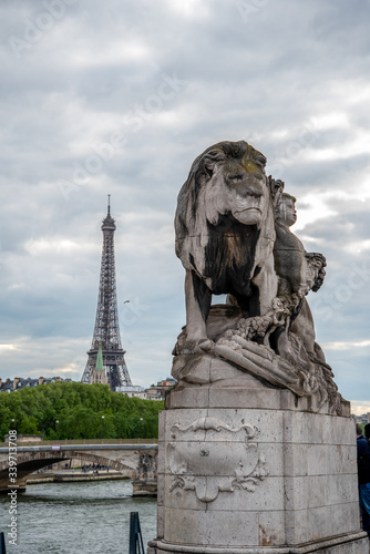 Statue of a Lioin on Bridge Alexandre III, view to Eiffel tower, Paris/France