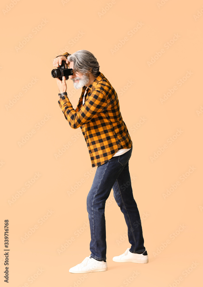 Fototapeta premium Handsome senior photographer on color background