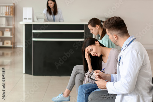 Male doctor with patient wo...