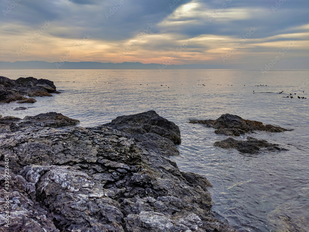 scenic view of the San Juan Island rocky coast with rolling, overcast clouds scenic view of the San Juan Island rocky coast with rolling, overcast clouds