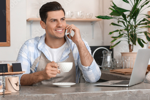 Smiling male barista talkin...